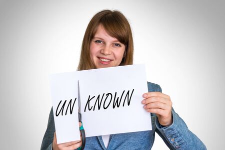 Business woman cutting paper by scissors with unknown word, she makes known word - business idea conceptの写真素材