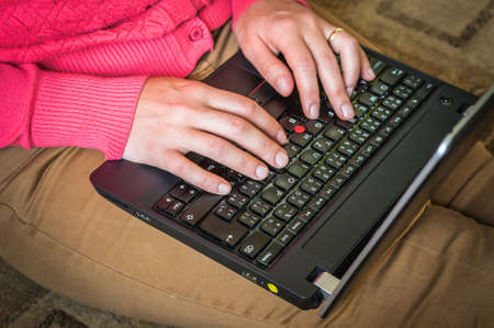 Young woman sitting on the floor with laptopの写真素材