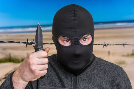 Terrorist threatening western countries with knife - terrorism and hybrid warfare conceptの写真素材