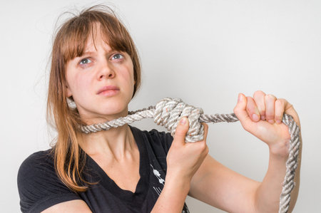 Depressed woman with a noose around her neck isolated on white - suicide concept