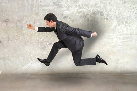 Small businessman with suit running away from a boss pressureの写真素材