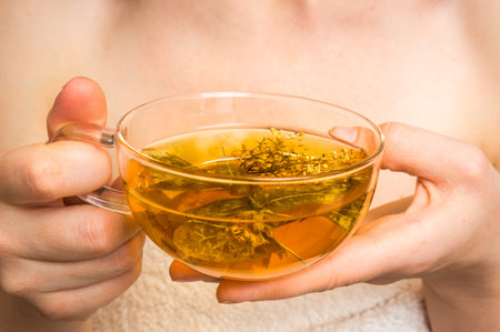 Beautiful young woman with hot tea cup in her hands