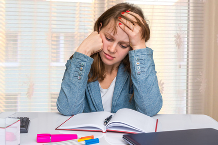 Sad young business woman is working in the officeの写真素材