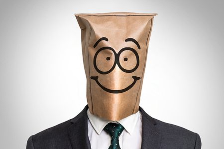 Businessman with a paper bag on the head - with smile faceの写真素材
