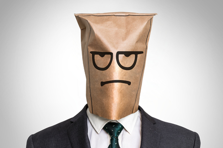Businessman with a paper bag on the head - with sad faceの写真素材