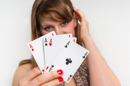 Beautiful girl hides behind poker cards - casino gambling concept