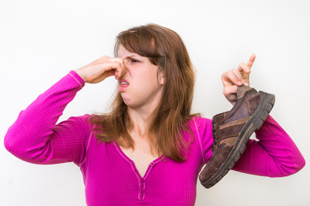 Woman with stinky shoe of her husband - unpleasant smell conceptの写真素材