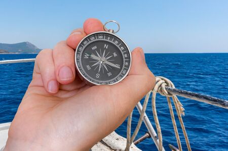 Woman with compass is seeking a right way on sea - navigation conceptの写真素材