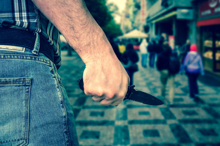 Killer is attacking with knife on crowd of people in public place - murder and crime concept - retro styleの写真素材