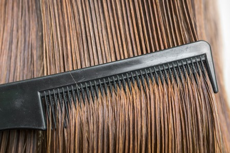 Close-up of dark wet hair with black comb - hair care conceptの写真素材