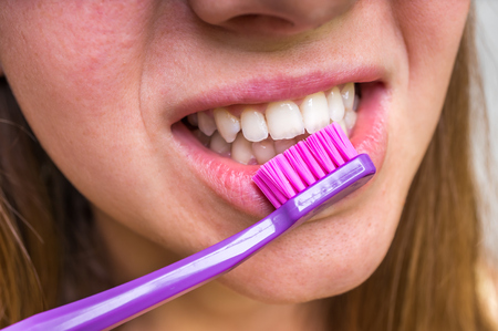Woman brushing her teeth with toothbrush in the morning - dental care conceptの写真素材