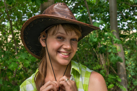 Sexy woman with leather cowboy hat in parkの写真素材