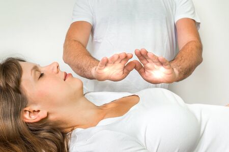 Young woman getting reiki healing therapy - alternative medicine conceptの写真素材