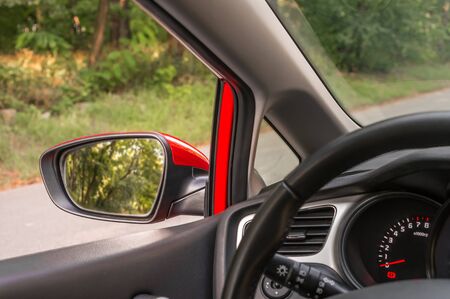Close-up view of rearview mirror on the red carの写真素材