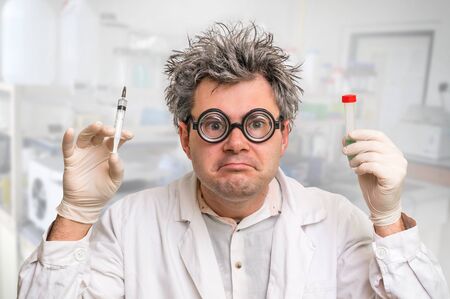 Crazy scientist with gray hair performing experiments in laboratoryの写真素材