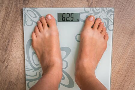 Female feet on personal scales - obesity and diet conceptの写真素材