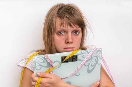Overweight woman holding digital scales with word HELP! - diet and obesity conceptの写真素材