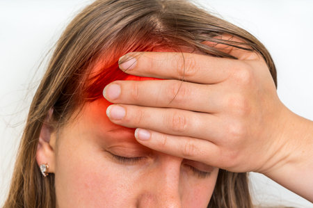 Woman with headache or migraine is holding her aching forehead - body pain concept
