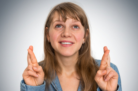 Attractive woman crossing her fingers for good luckの写真素材