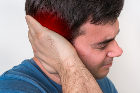 Man with earache is holding his aching ear - body pain conceptの写真素材