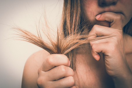 Woman with hair problems - brittle, damaged, dry, dirty and loss hair concept - retro styleの写真素材