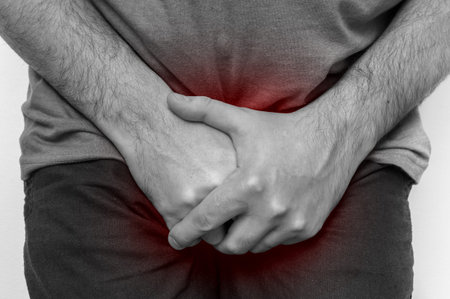 Man with incontinence problem is holding his crotch - black and white photo