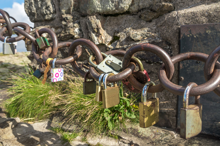 A lot of love padlocks on chain on the top of mountain - romantic concept of loveの写真素材