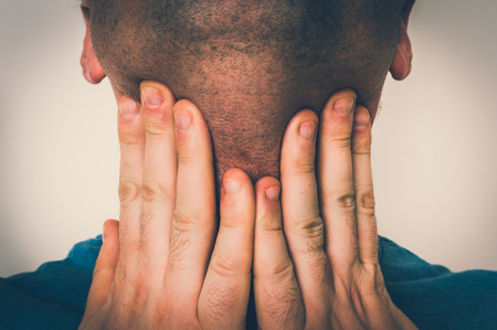 Man with throat sore is holding his aching throat - body pain concept - retro styleの写真素材