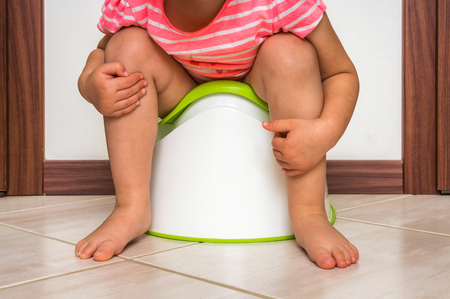 Child is sitting on baby potty - toilet training conceptの写真素材