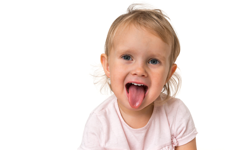 Little baby girl showing tongue isolated on white backgroundの写真素材