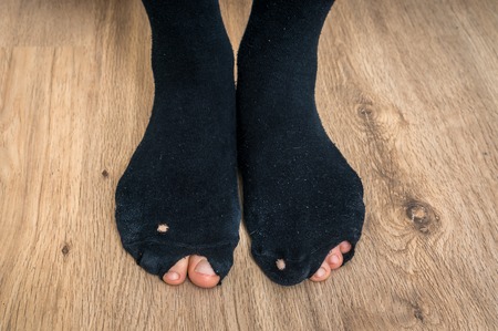 Worn socks with a holes and a fingers sticking out of them - economic crisis conceptの写真素材