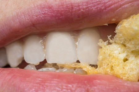 Macro photography of woman mouth with eating foodの写真素材