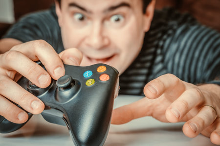 Emotional addicted man playing video games in living room