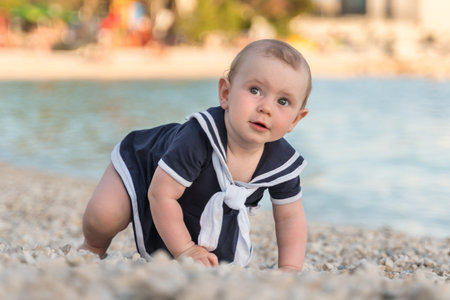 Cute little baby girl on the beach near seaの写真素材