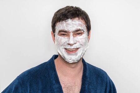 Funny man with natural white cream mask on his face - spa and beauty conceptの写真素材
