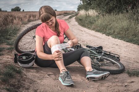 Young woman fallen from mountain bicycle - accident on bikeの写真素材