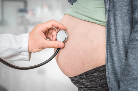 Pediatrician doctor with stethoscope is listening to heartbeat baby of pregnant woman - pregnancy...