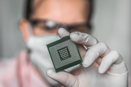 Young scientist showing the computer microchip - researching new technologiesの写真素材
