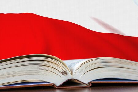 Education in Poland. Opened book and national flag on background. 3D rendered illustration.の写真素材