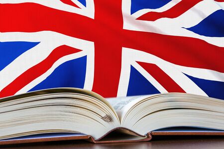 Education in United Kingdom. Opened book and national flag on background. 3D rendered illustration.の写真素材