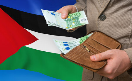 Investing money to Palestine. Rich man with a lot of money in his hands and national flag on background.の写真素材