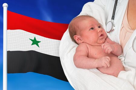 Birth rate in Syria. Newborn baby in hands of doctor on national flag background.の写真素材
