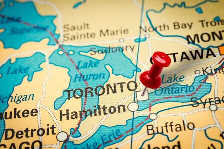 PRAGUE, CZECH REPUBLIC - JANUARY 12, 2019: Red thumbtack in a map. Pushpin pointing at Toronto city in Canada.の写真素材
