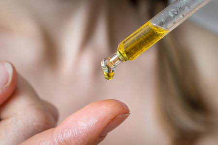 Woman is applying moisturizing body oil on her finger - skin care concept