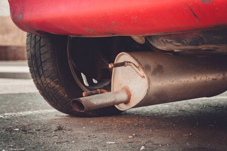 Car exhaust (muffler) fallen off a car - forgotten car on street conceptの写真素材
