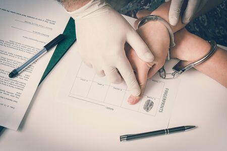 Police takes fingerprints of a criminal - investigation on the crime - retro styleの写真素材