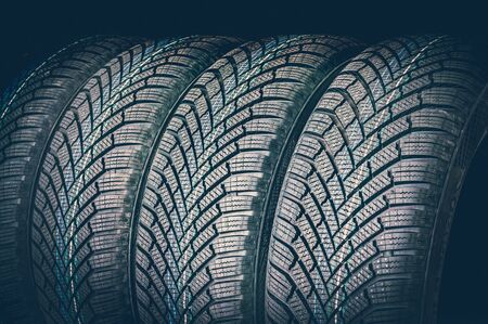 Winter car tires in a row isolated on black background - retro styleの写真素材