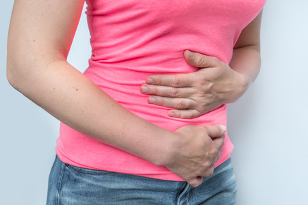 Woman with menstrual pain is holding her aching belly - body pain conceptの写真素材