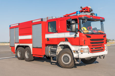 Red fire truck on the airport runway with equipment for firefighting operations