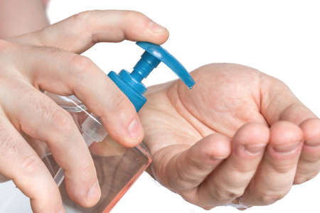 Man is applying antibacterial gel, sanitiser on his hands - hygiene conceptの写真素材